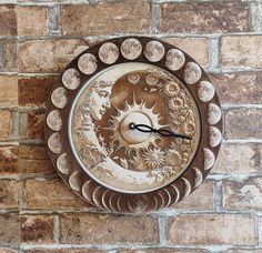 a clock on the side of a brick wall with sun and moon designs painted on it