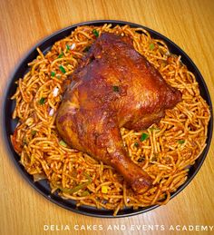 a black plate topped with chicken and noodles