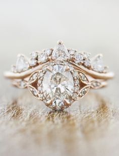 an engagement ring with a pear shaped diamond surrounded by smaller pear shaped diamonds on top