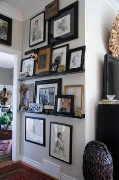 a living room with pictures on the wall and an entertainment center in the corner next to it