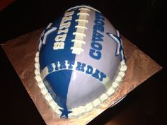 a cake that is sitting on top of a brown paper bag with the words cowboys in blue and white