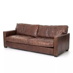 a brown leather couch sitting on top of a white floor