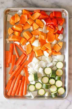 carrots, cucumbers and celery on a baking sheet in a pan