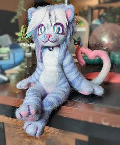 a stuffed cat sitting on top of a wooden table