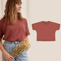 a woman standing next to a t - shirt and some dried flowers in her hand