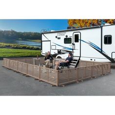 two people sitting on benches in front of an rv with the trailer attached to it