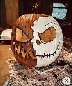 a pumpkin decorated with the face of jack - o'- lantern on top of newspapers