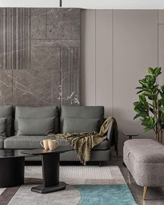 a modern living room with grey couches and coffee table in front of the wall