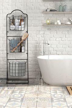 a white bath tub sitting next to a brick wall in a bathroom with tile flooring