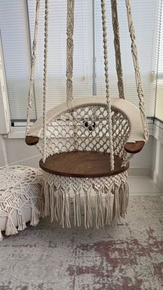 a white hanging chair and ottoman in a room