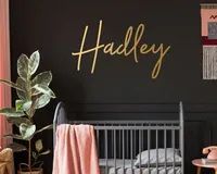 a baby's room with black walls and gold lettering on the wall