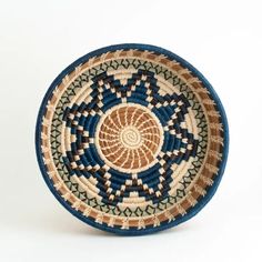 a blue and brown bowl with an intricate design on the bottom, sitting on a white surface