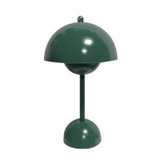 a green table lamp sitting on top of a white wall