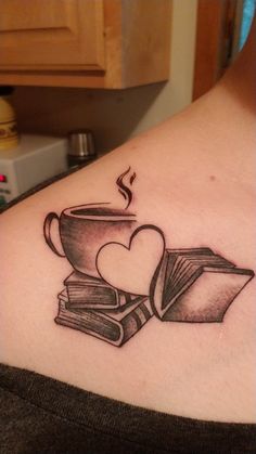 a woman with a tattoo on her chest has books and a cup of coffee in the shape of a heart