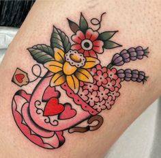 a woman's thigh with flowers and hearts on it