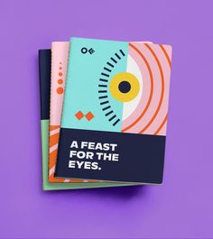 two notebooks with the words, a feast for the eyes on them against a purple background