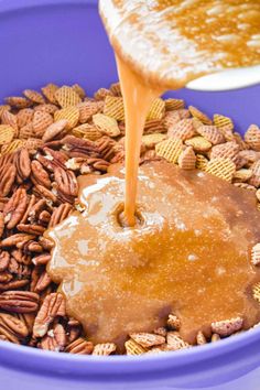 a blue bowl filled with cereal and caramel being poured into the mixture for a peanut butter pretzel snack