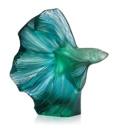 a glass fish sculpture sitting on top of a table