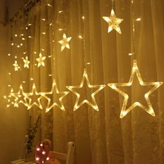 some lights that are hanging from the ceiling in front of a curtain with stars on it