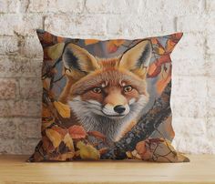 a pillow with an image of a fox on it's face and leaves surrounding it