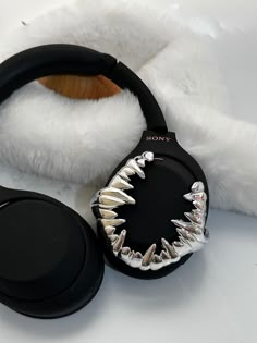 a pair of headphones with spikes on them sitting next to a stuffed animal bear