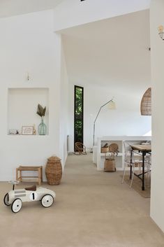 a toy car sitting in the middle of a room with white walls and flooring