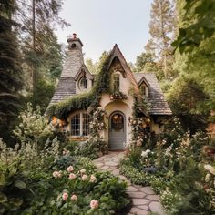 a small house surrounded by flowers and greenery