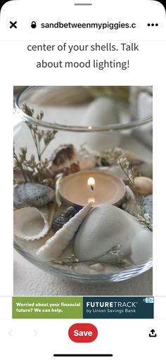 a glass bowl filled with sea shells and a lit candle