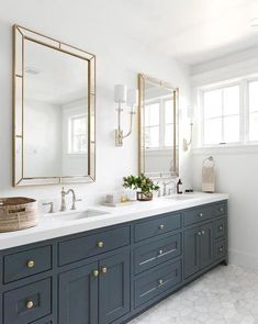 a bathroom with two sinks and large mirrors on the wall next to eachother