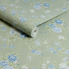 a roll of toilet paper sitting on top of a floral wallpaper covered in blue flowers