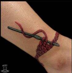 a tattoo on the foot of a person with a red ribbon and two crossed swords