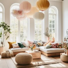 a living room filled with lots of furniture and large round lamps hanging from the ceiling