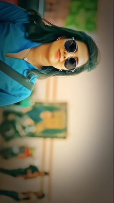 a woman with green hair wearing sunglasses and a blue dress