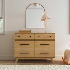 a wooden dresser with a mirror and lamp in a white living room, next to a window