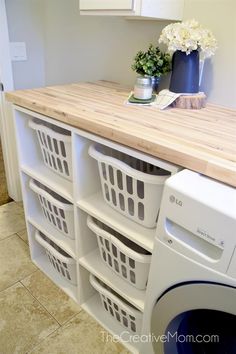 a washer and dryer sitting next to each other in a room with tile flooring