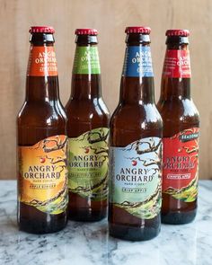 four bottles of beer sitting on top of a marble countertop next to each other