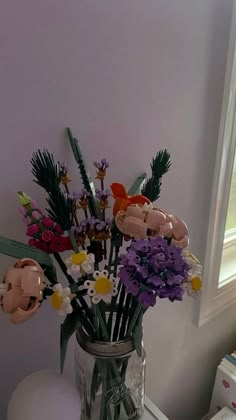 a vase filled with flowers sitting on top of a white table next to a window