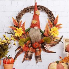 a wreath with an image of a gnome surrounded by fall leaves and flowers