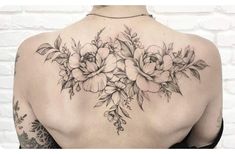 the back of a woman's shoulder with flowers and leaves on her left side