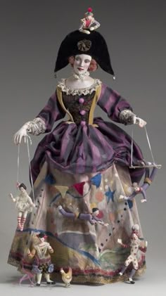 an old fashion doll with many dolls attached to it