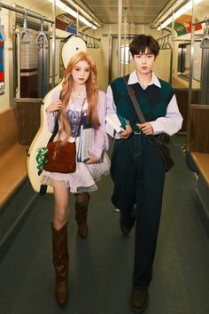 two people dressed in costumes are walking down the subway train together, one is holding a book and the other is carrying a purse