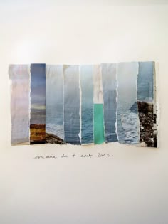 an art piece with torn pieces of paper on top of it and the ocean in the background