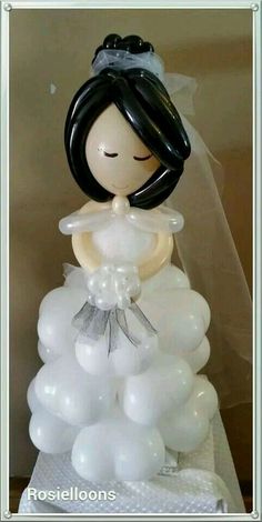 a wedding cake topper with balloons in the shape of a bride's dress