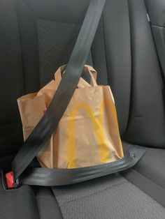 a brown bag sitting in the back seat of a car with a yellow mcdonald's logo on it