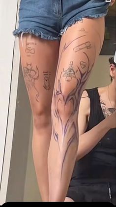 a woman with tattoos on her legs is looking in the mirror