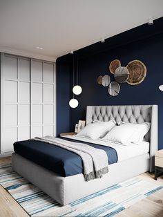 a bedroom with blue walls, white bedding and an upholstered headboard