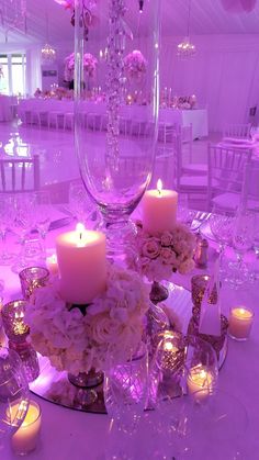 a centerpiece with flowers and candles on a table