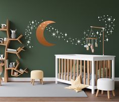 a baby's room decorated in green and white with stars, moon and crib