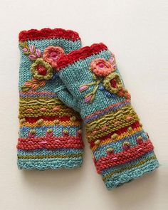 two colorful knitted mittens sitting on top of each other