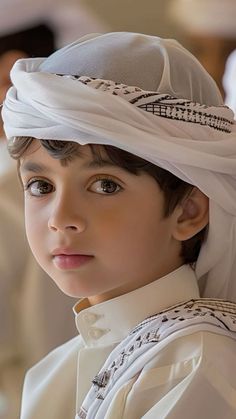 a young boy wearing a white turban